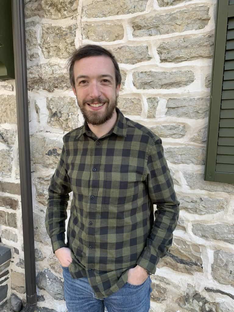 Ian Keir in front of a stone house